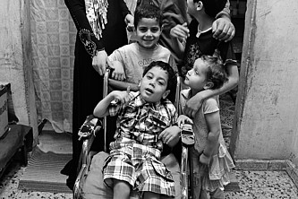 Nour sitzt in einem Rollstuhl, er ist von seinen vier Geschwistern umgeben.