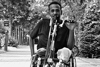Abdi Karshe im Rollstuhl mit Handkurbel.