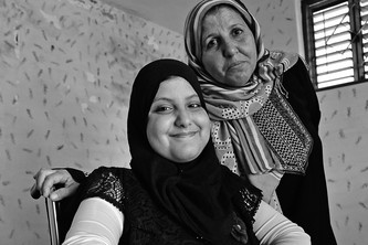 Lubna lächelt in die Kamera. Die Mutter blickt ernster.