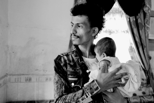 Abdullah hält sein Baby im Arm