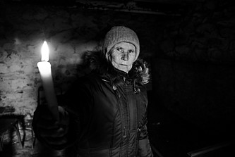 Valentina hält in einem Keller eine Kerze hoch.