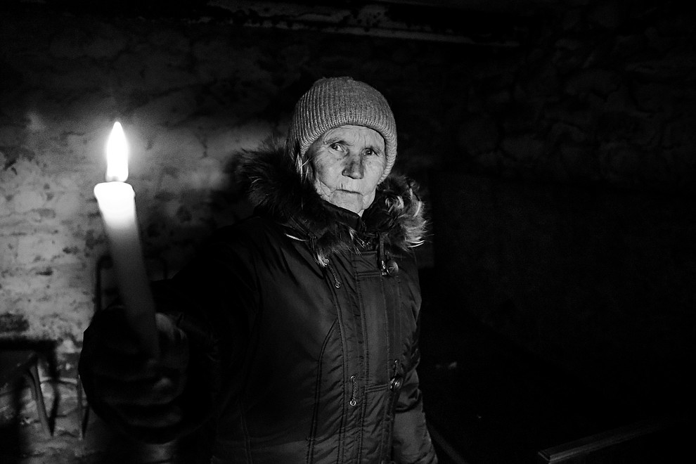 Valentina hält in einem Keller eine Kerze hoch.
